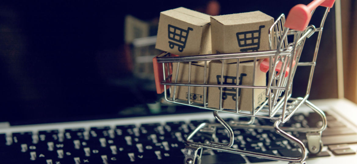 Shopping online concept - Parcel or Paper cartons with a shopping cart logo in a trolley on a laptop keyboard. Shopping service on The online web. offers home delivery..